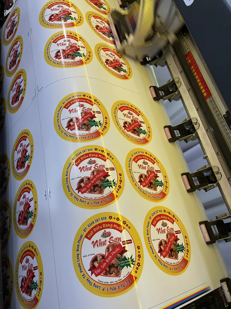 cuộn decal tem đang chạy trên máy in khổ lớn tại xưởng In Đức Lộc