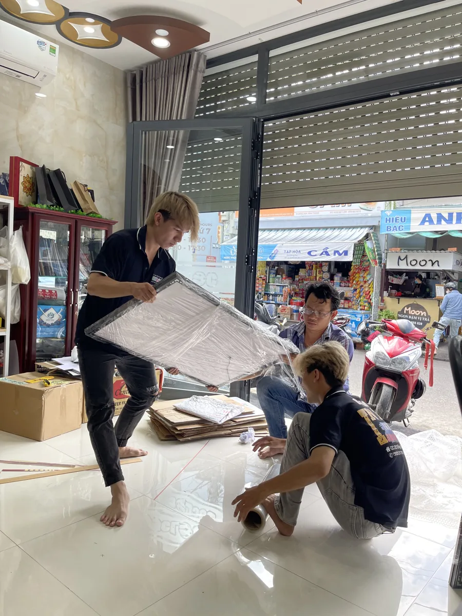 thợ đang xử lý bản in khổ lớn trong xưởng