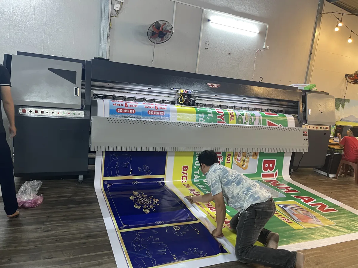 thợ đang xử lý bản in trên dàn máy khổ lớn trong xưởng In Đức Lộc
