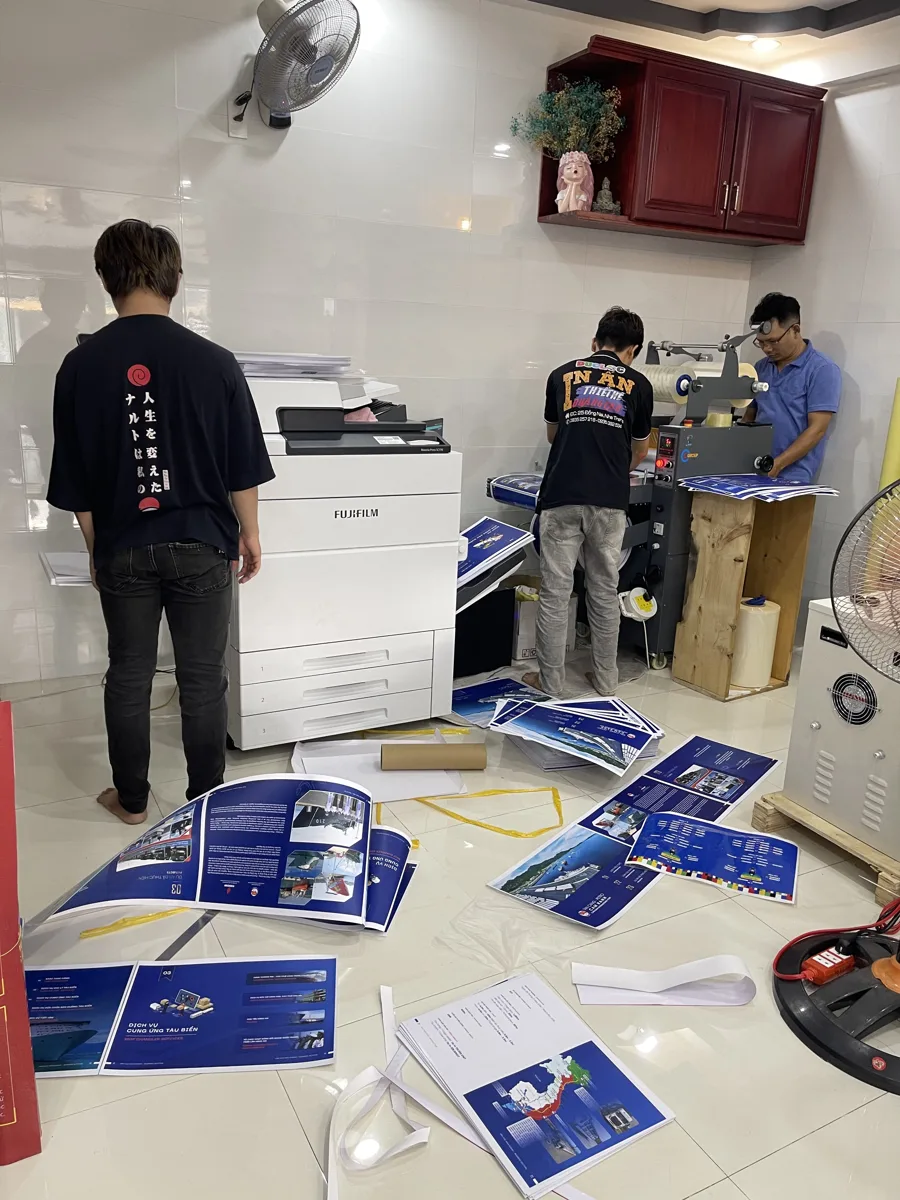 đội ngũ xưởng đang xử lý đơn in nhanh quanh máy in