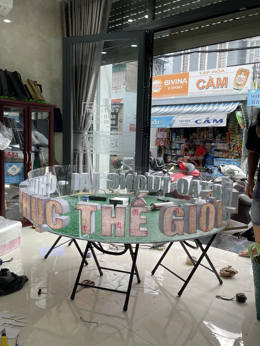 Dãy chữ nổi thành phẩm dựng trước cửa kính văn phòng In Đức Lộc Nha Trang