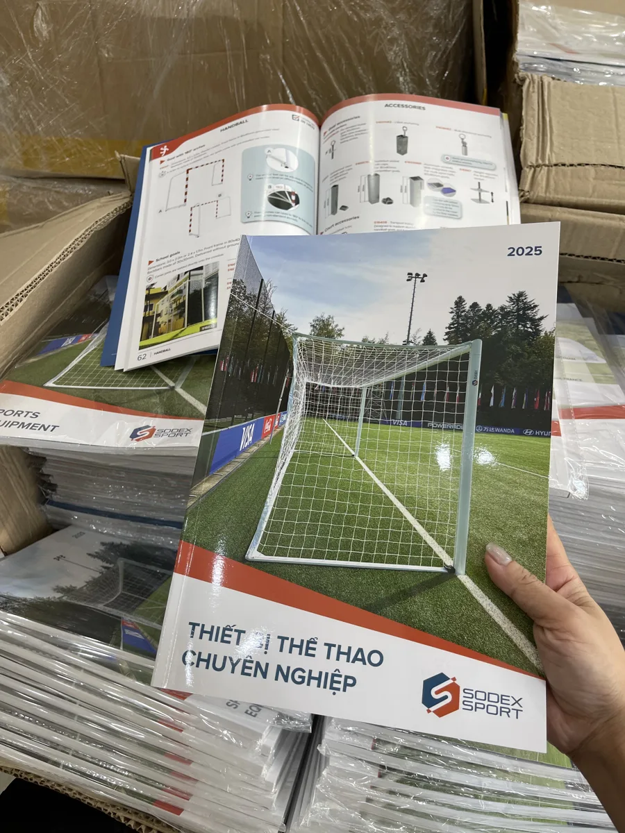 Tay cầm cuốn catalogue thiết bị thể thao thành phẩm tại xưởng In Đức Lộc Nha Trang
