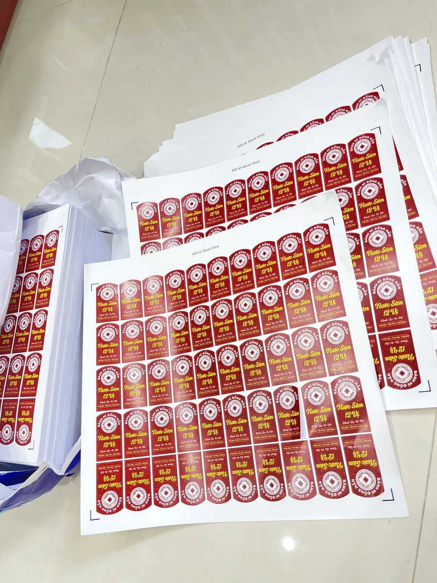 Chồng tờ decal nhựa vừa in xong tại xưởng In Đức Lộc, chờ bế và giao khách