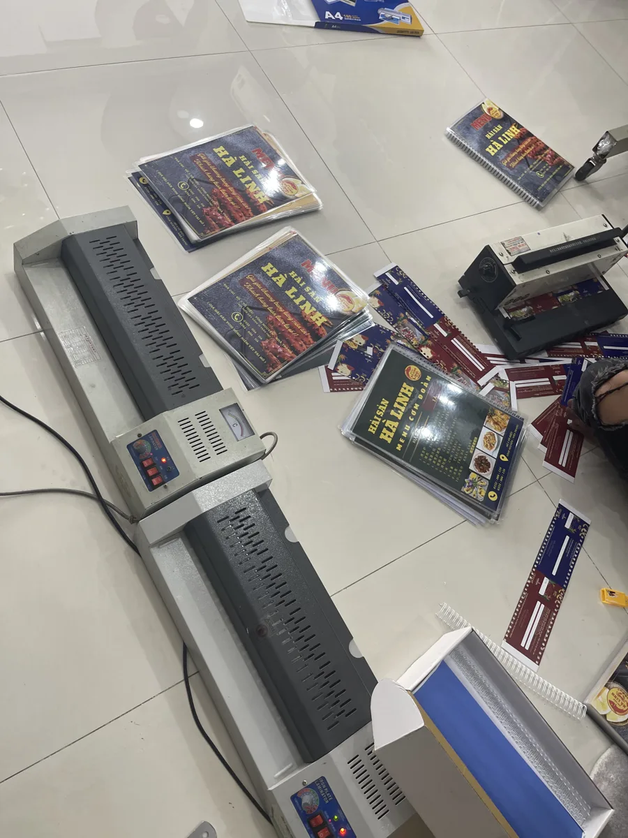 Máy ép plastic và các tờ in A4 đang gia công tại In Đức Lộc