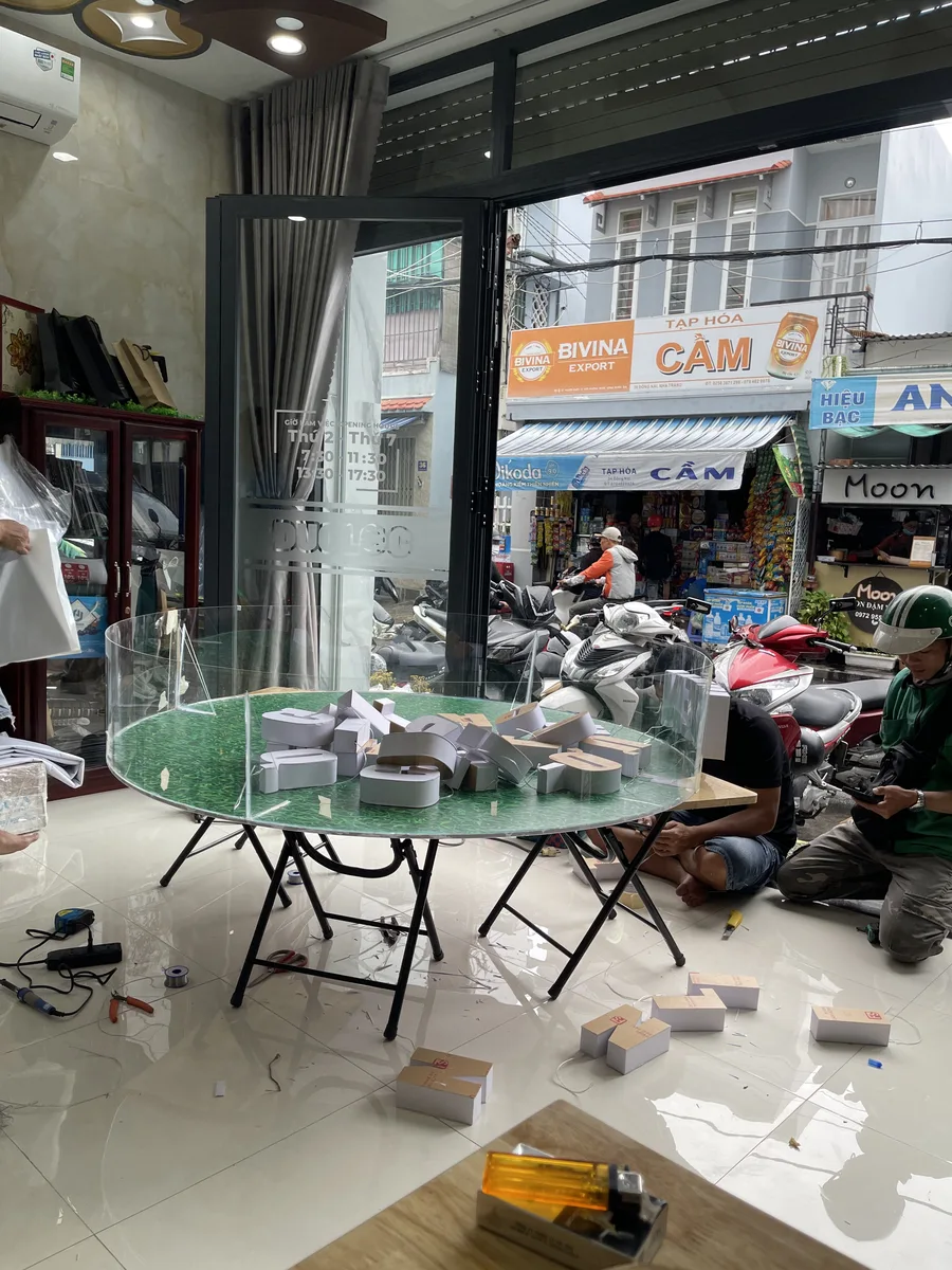 Thợ lắp ráp chữ nổi tại văn phòng In Đức Lộc, nhìn qua cửa kính ra mặt tiền phố Nha Trang